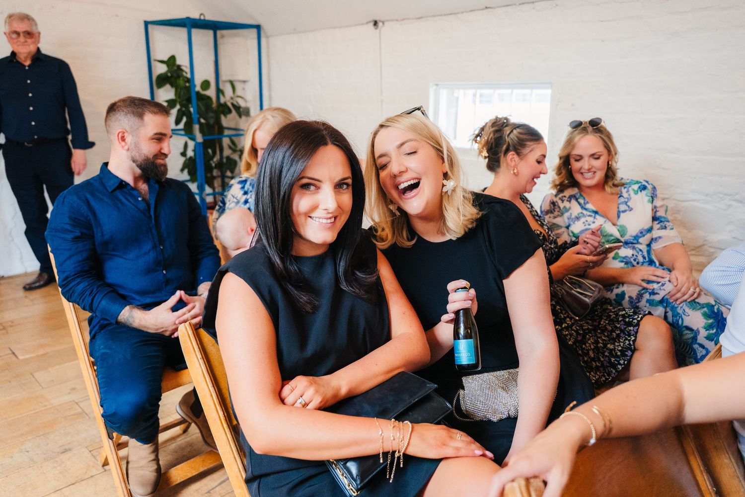 Wedding guests laughing and enjoying themselves during indoor reception celebration. Same sex wedding PHOTOGRAPHER Dublin