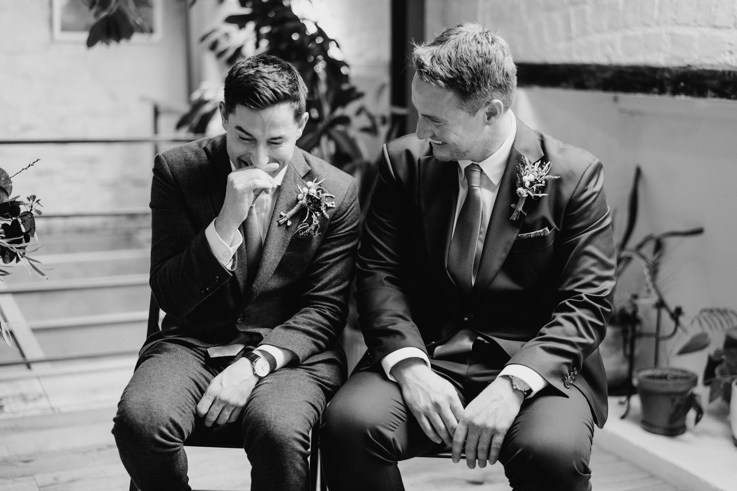 Wedding party members in dark suits seated together during ceremony. Same sex wedding PHOTOGRAPHER Dublin