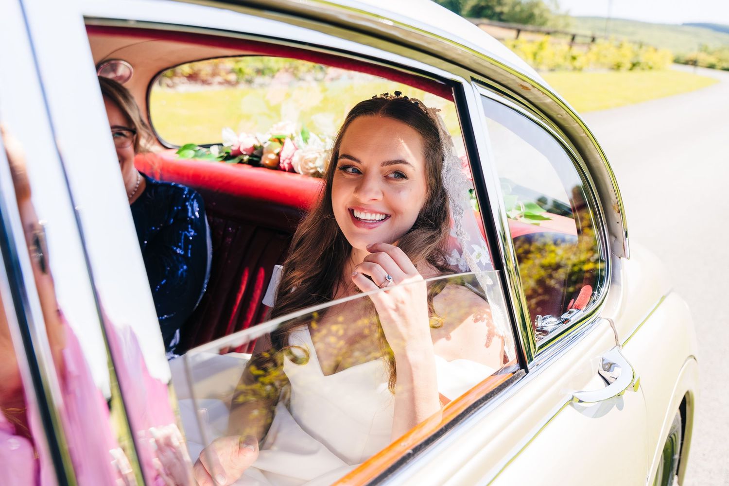 Poulaphouca Wedding photographer wicklow  Classic vintage car adorned with wedding decorations on a sunny day.