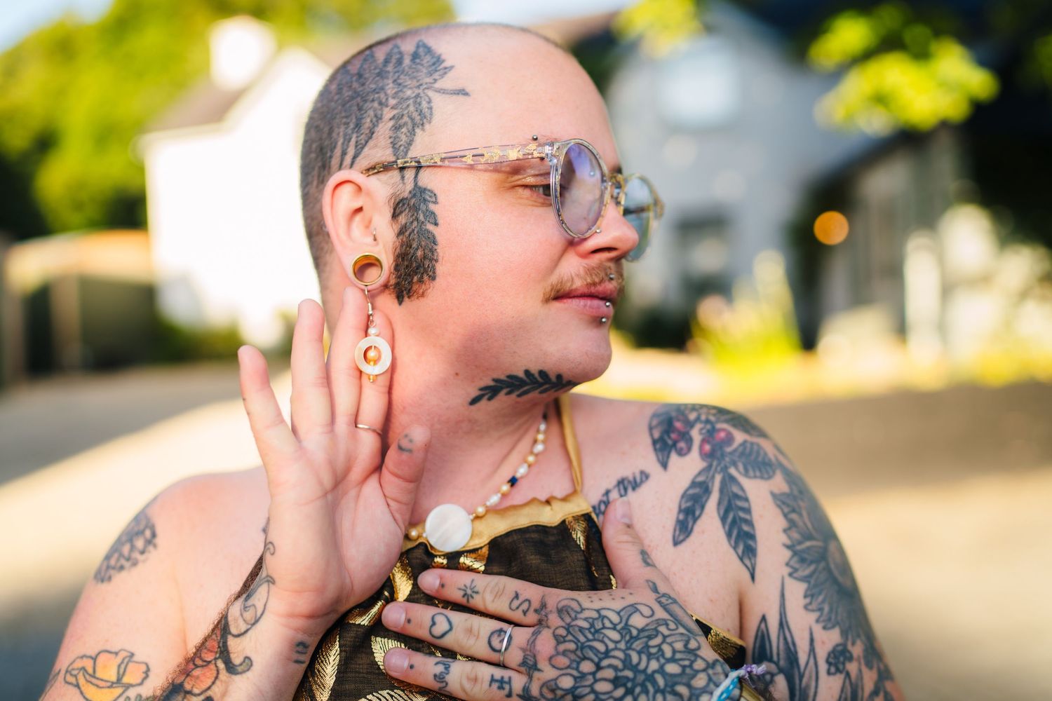 Poulaphouca Wedding photographer wicklow Close up of heavily tattooed person with facial art in sunlight.