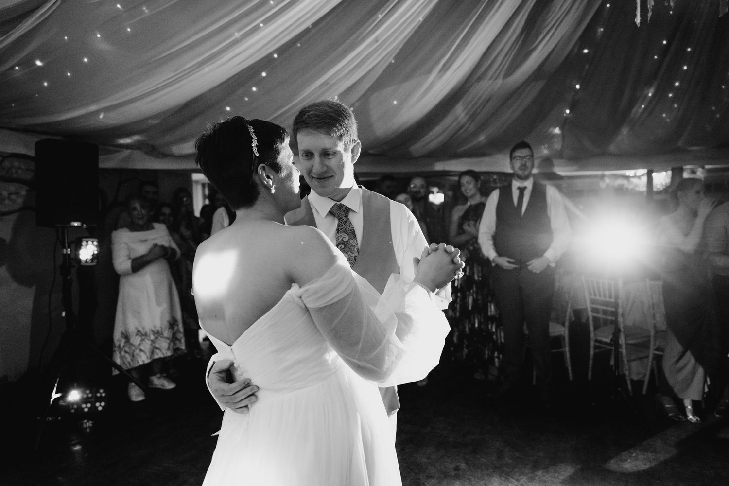 Black and white photo series showing people joyfully dancing at a wedding reception under draped fabric decor.Millhouse slane wedding photog