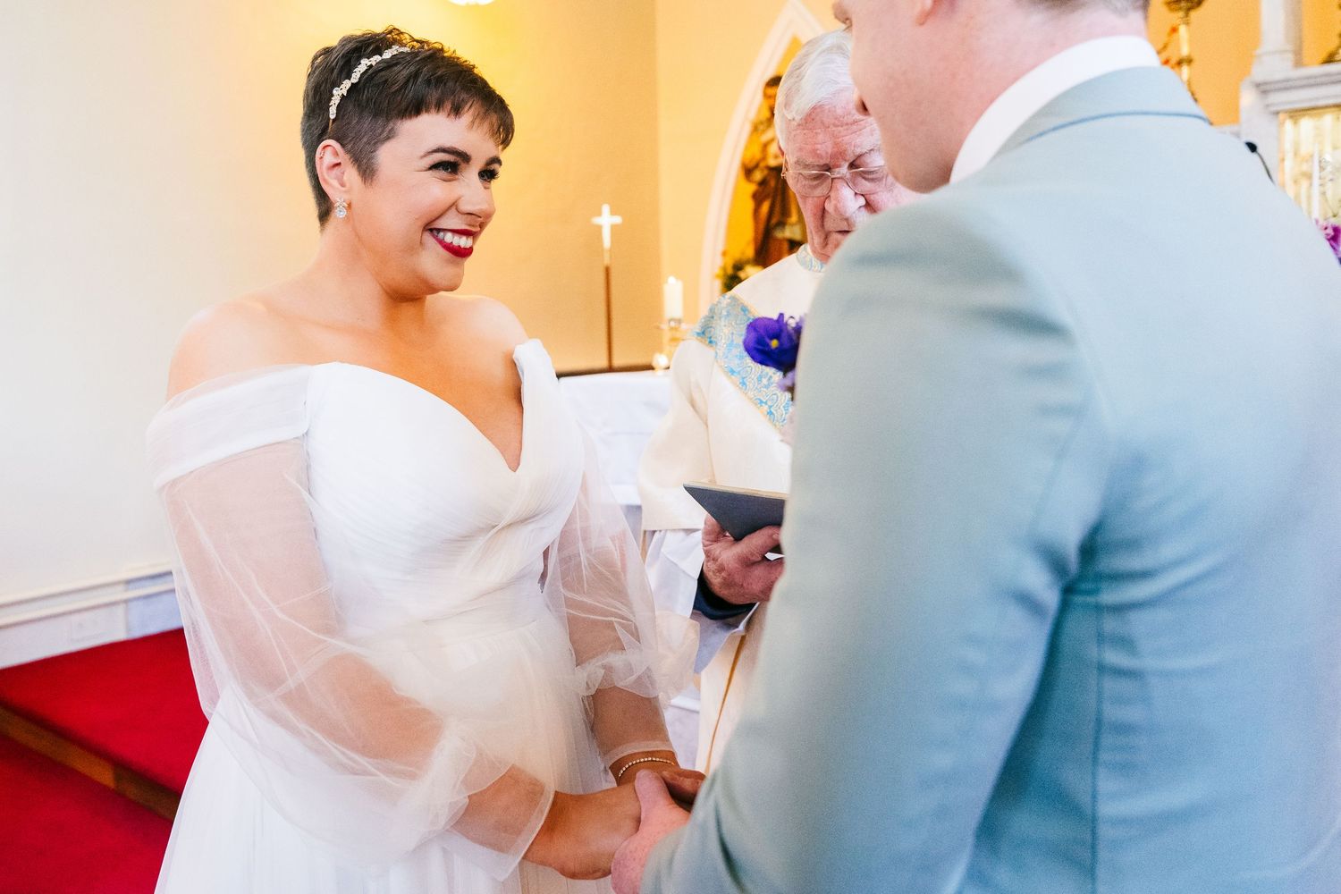 Millhouse slane wedding photographer dublin Wedding ceremony candid moments in a church with light blue and white attire.
