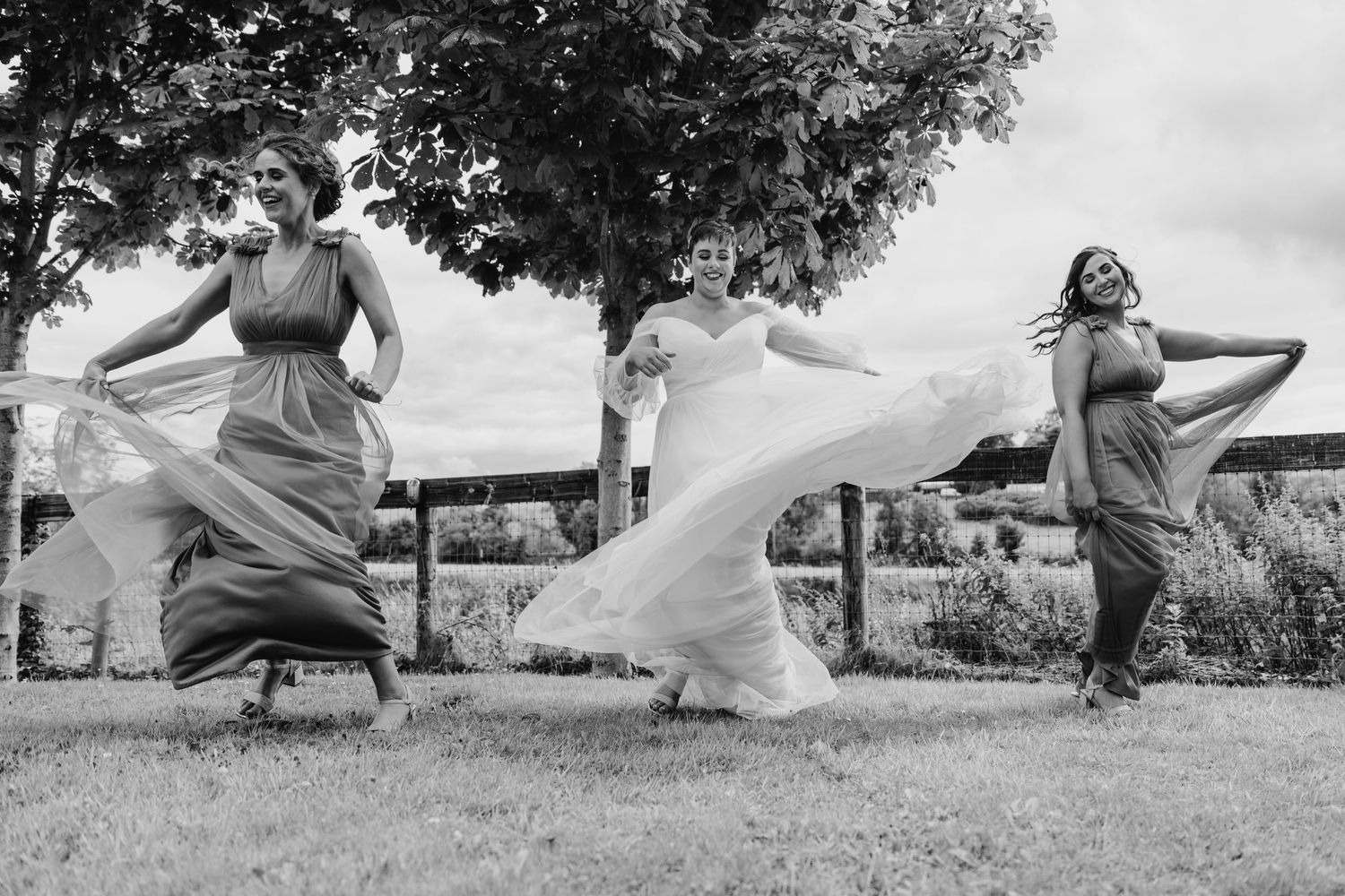 Millhouse slane wedding photographer dublin Black and white photo of people jumping and playing on a grassy hill.