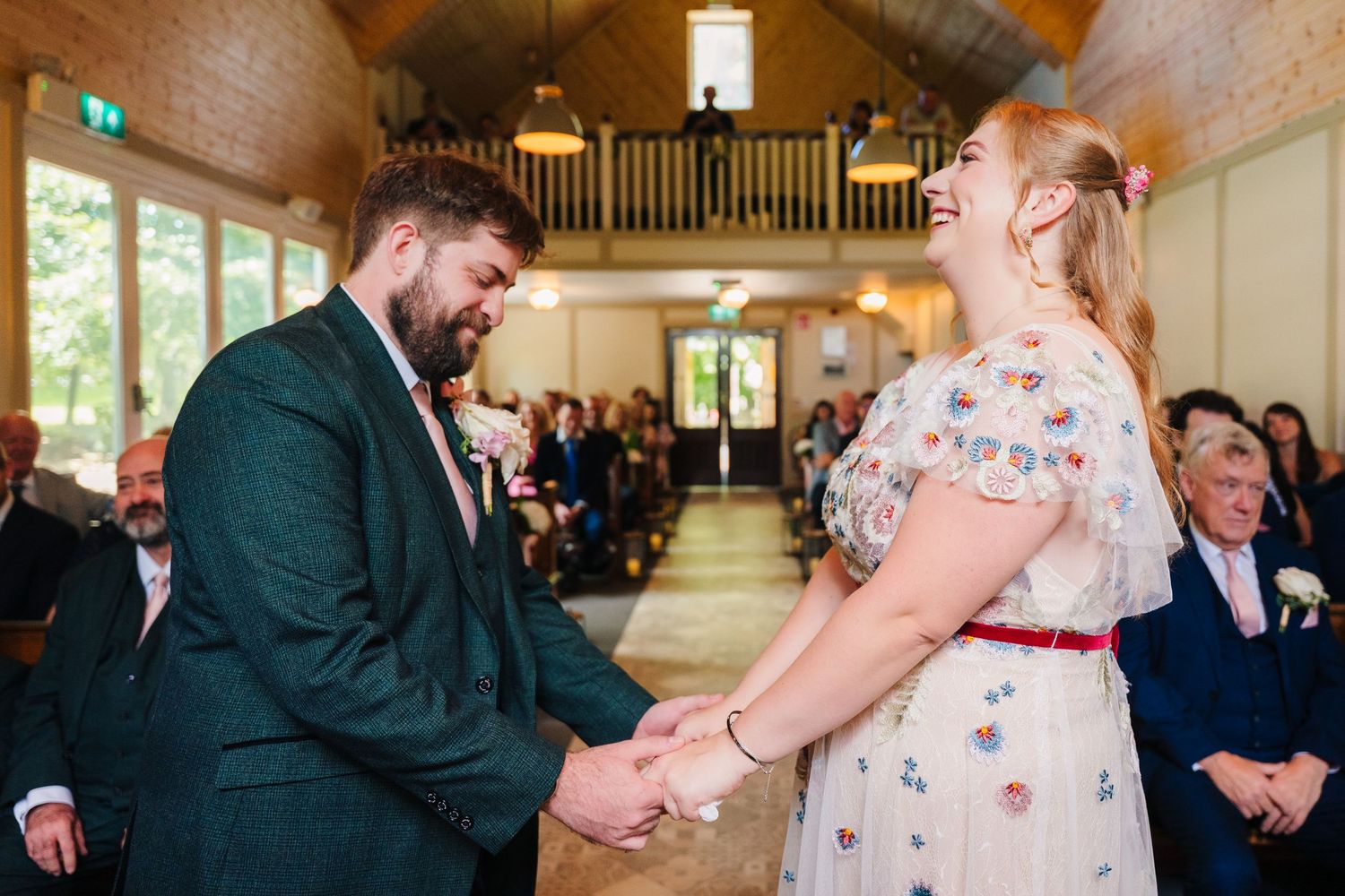 A couple shares an emotional moment during their wedding ceremony in a rustic chapel. . Village Barn Tyrrellspass wedding photographer Irela