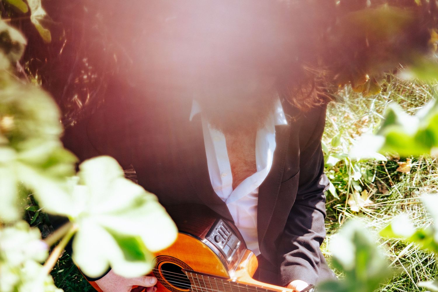 Dreamy filtered photo of guitar player through soft focus foliage. PHOTOGRAPHER Dublin
