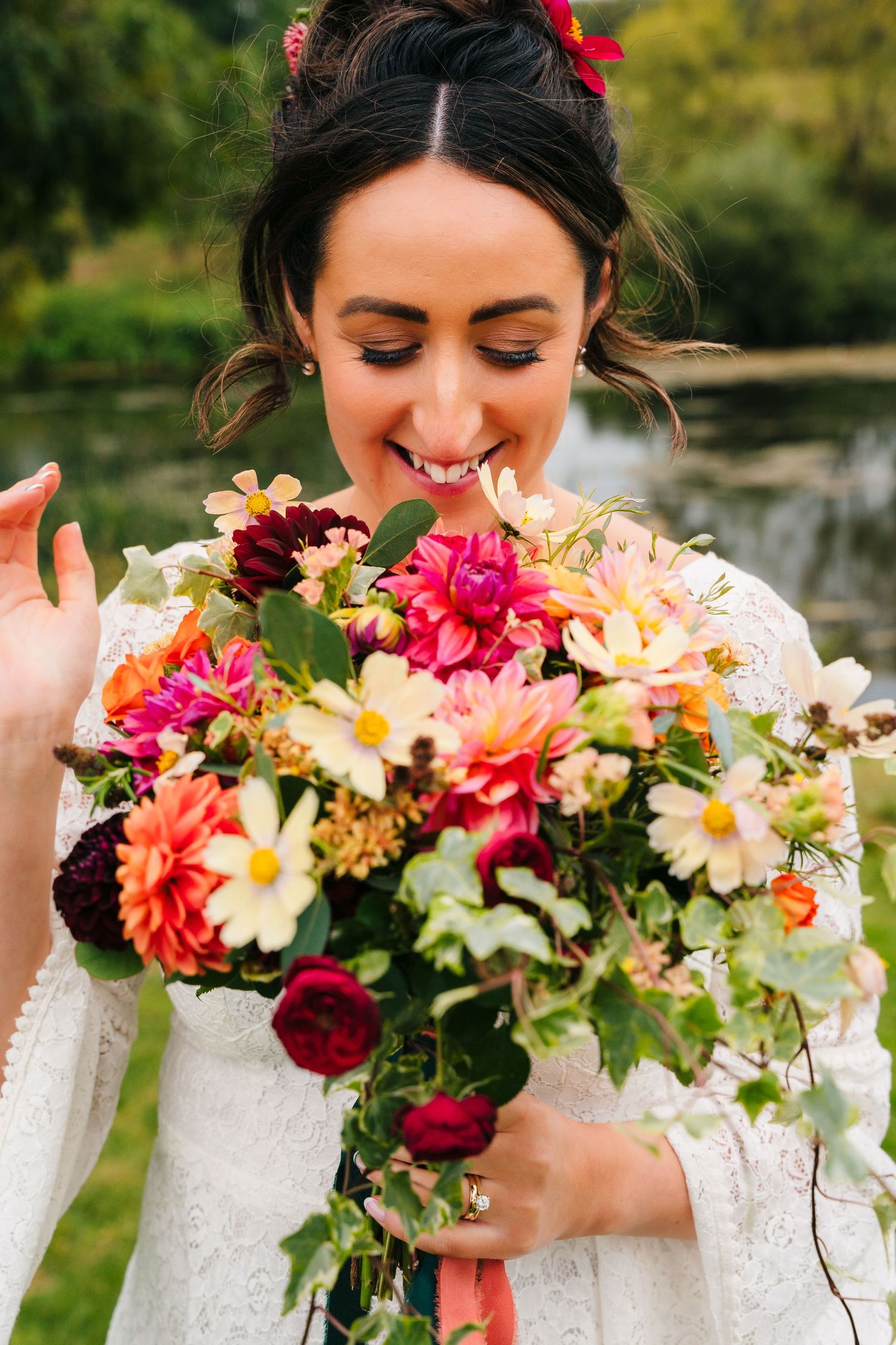 Colorful bridal bouquet featuring vibrant dahlias, roses and mixed flowers against a garden background.Wedding Photography Trim Castle Irela