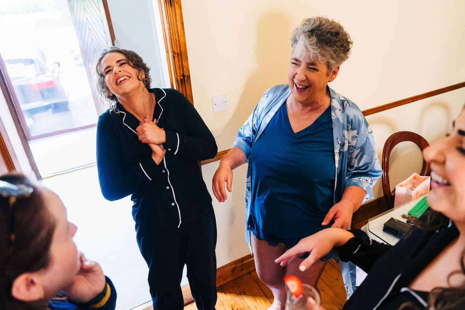 A candid moment captures people in matching navy sleepwear sharing an enthusiastic laugh together. Millhouse slane wedding photographer dubl