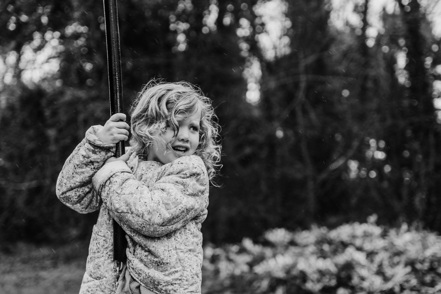 Family photographer Dublin Ireland  Black and white portrait showing genuine emotion while holding playground equipment.