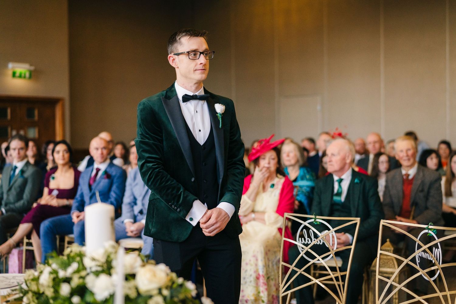 Wedding reception guests seated at elegant dining tables with white tablecloths and floral centerpieces.  Wedding PHOTOGRAPHER Trim Castle