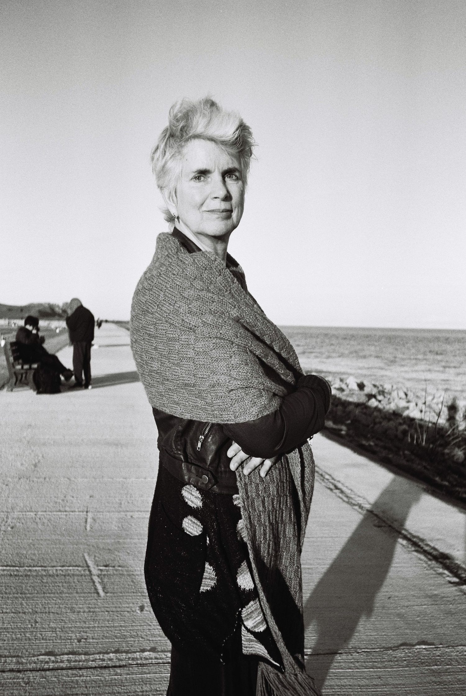 A black and white photo sequence shows a figure in dark clothing turning around on a boardwalk by the ocean. HEADSHOTS DUBLIN
