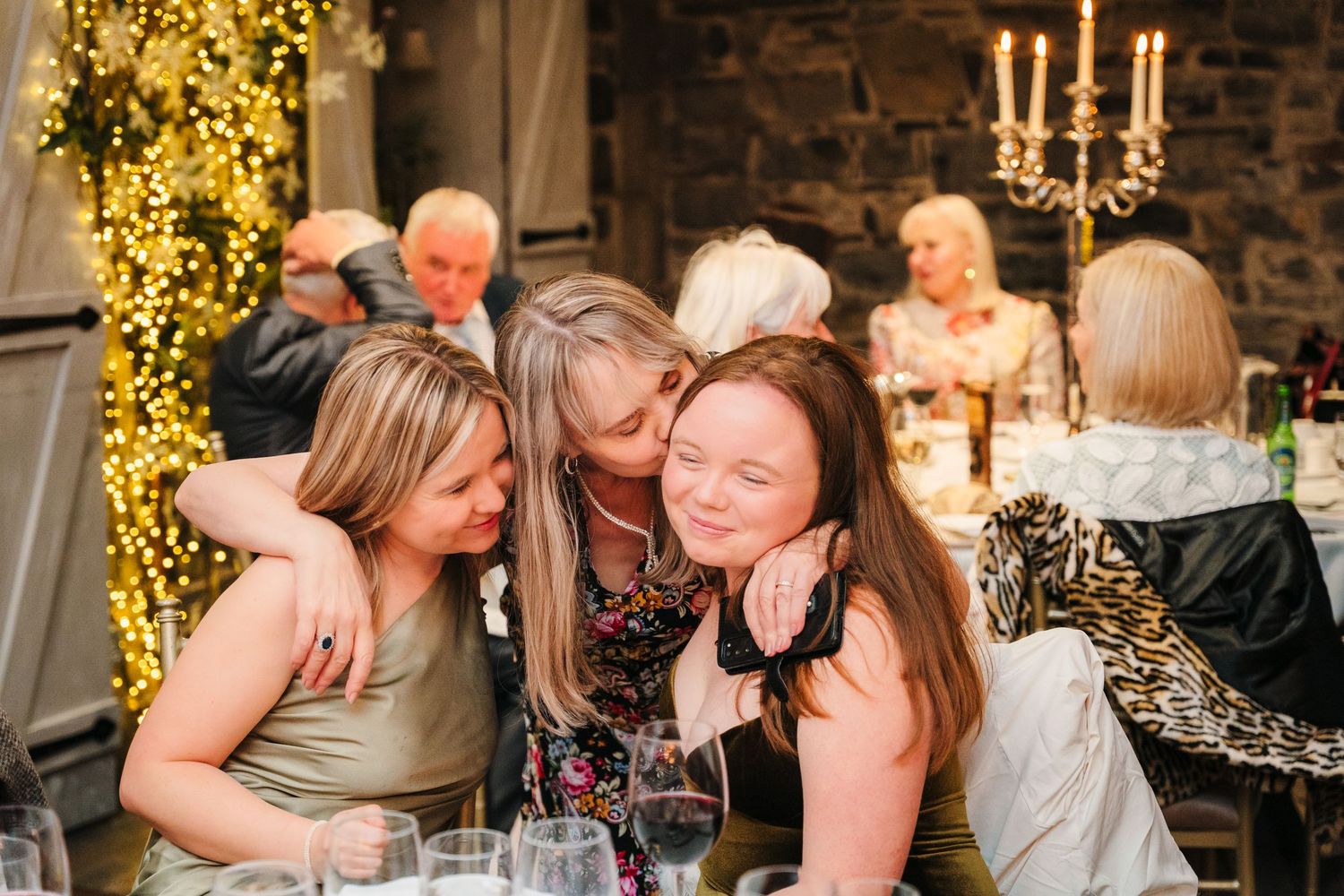 Wedding reception in rustic stone venue with glowing yellow lights and candelabras creating romantic ambiance. Ballymagarvey Wedding photogr