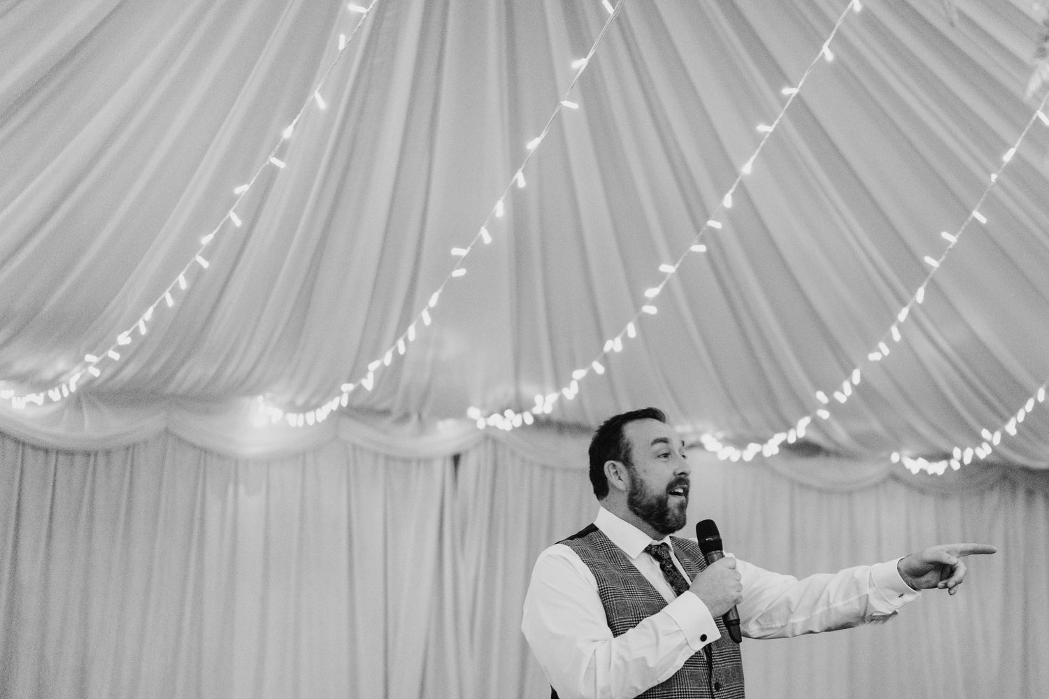 Black and white photo of a wedding reception with string lights and decorative ceiling draping.  Virginia Park Lodge Wedding Photographer Ca