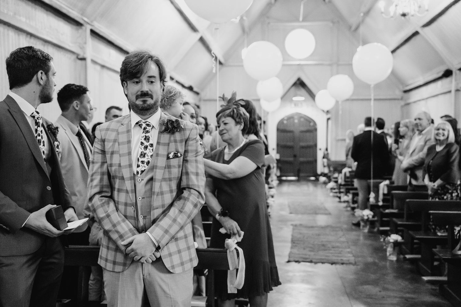 Wedding celebration in a white tent venue with hanging lanterns and gathered guests. Wedding photographer Dublin