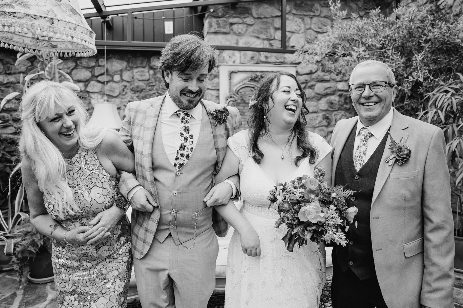Wedding party shares a candid laughing moment outside during the celebration. Wedding photographer Dublin