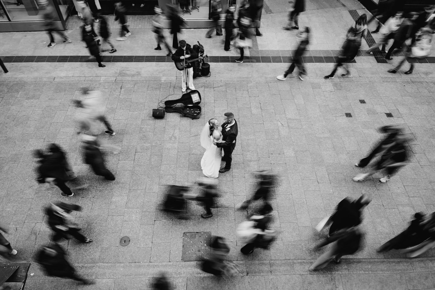 Black and white aerial view of people walking on a busy city street with motion blur effect. Wedding Photographer Dublin