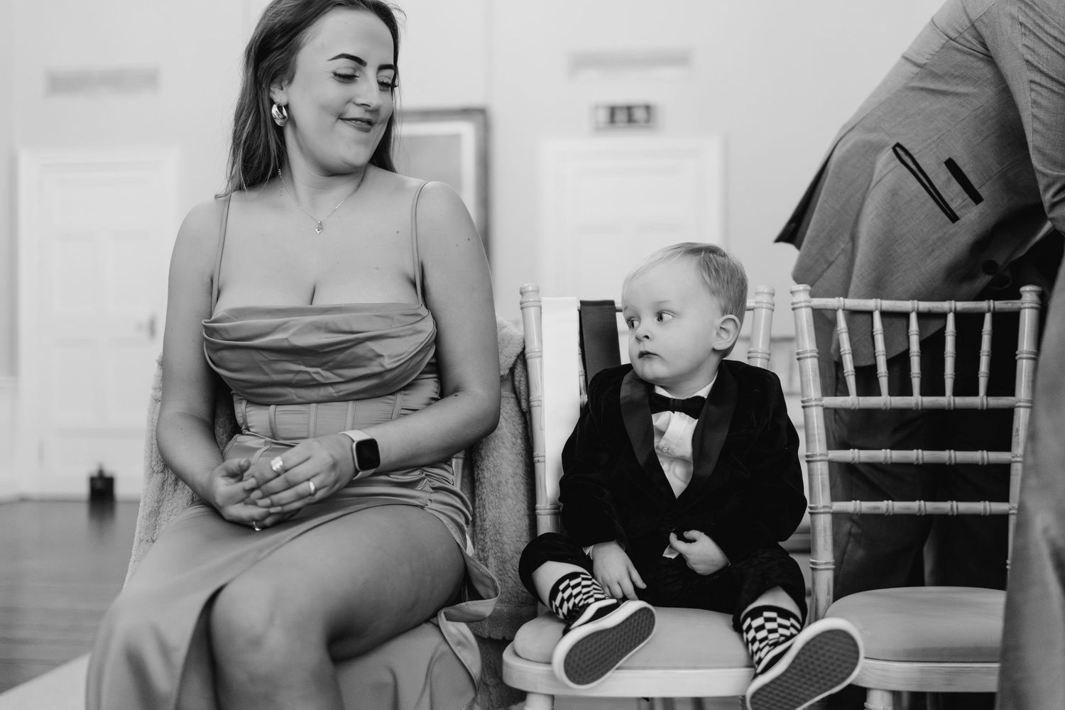 A candid black and white photo showing two people sitting together at an elegant formal event.  Wedding PHOTOGRAPHER Dublin