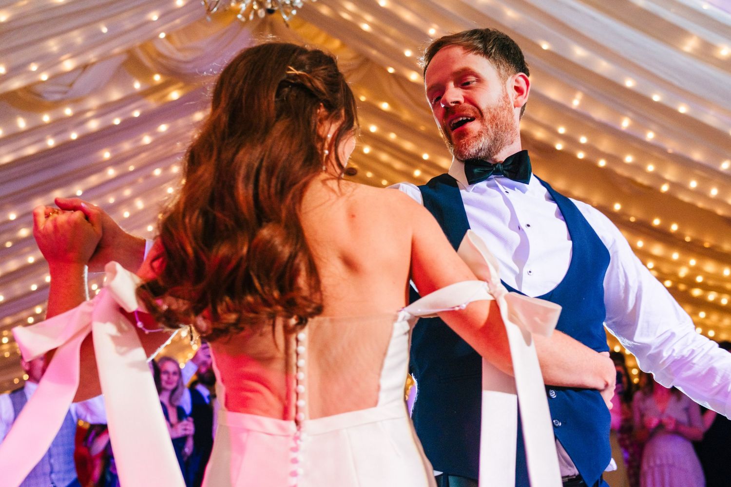 Castle Leslie Wedding Photographer Dublin Couple sharing romantic first dance under glowing string lights at wedding celebration.