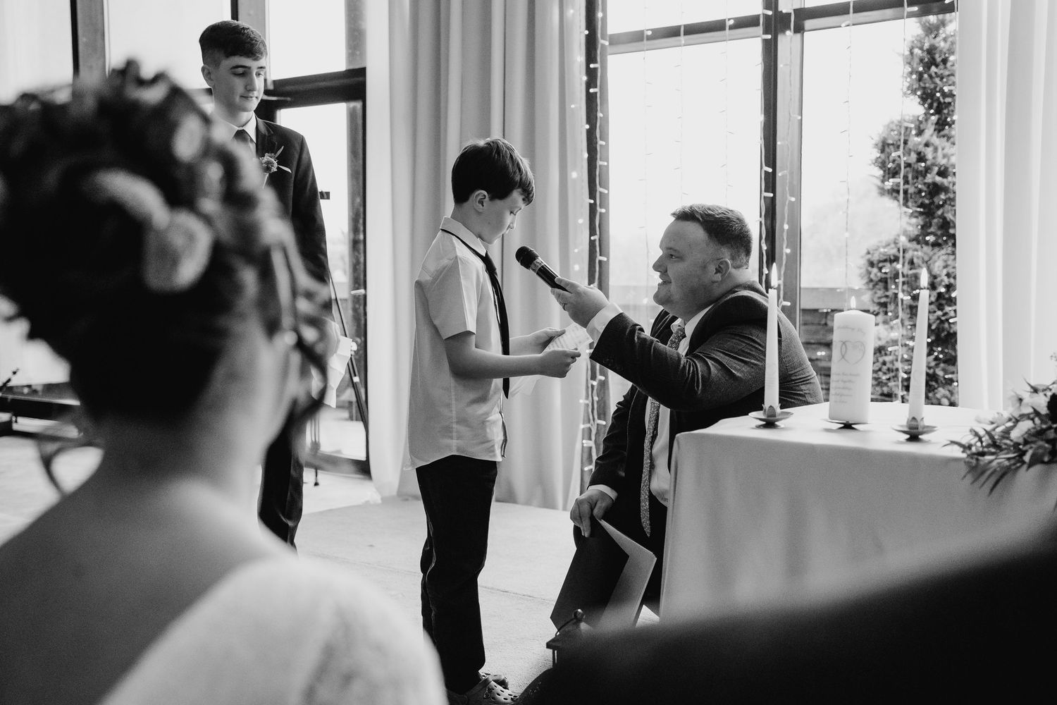 A black and white candid moment captured during a wedding ceremony indoors. Wedding Photography Trim Castle Ireland
