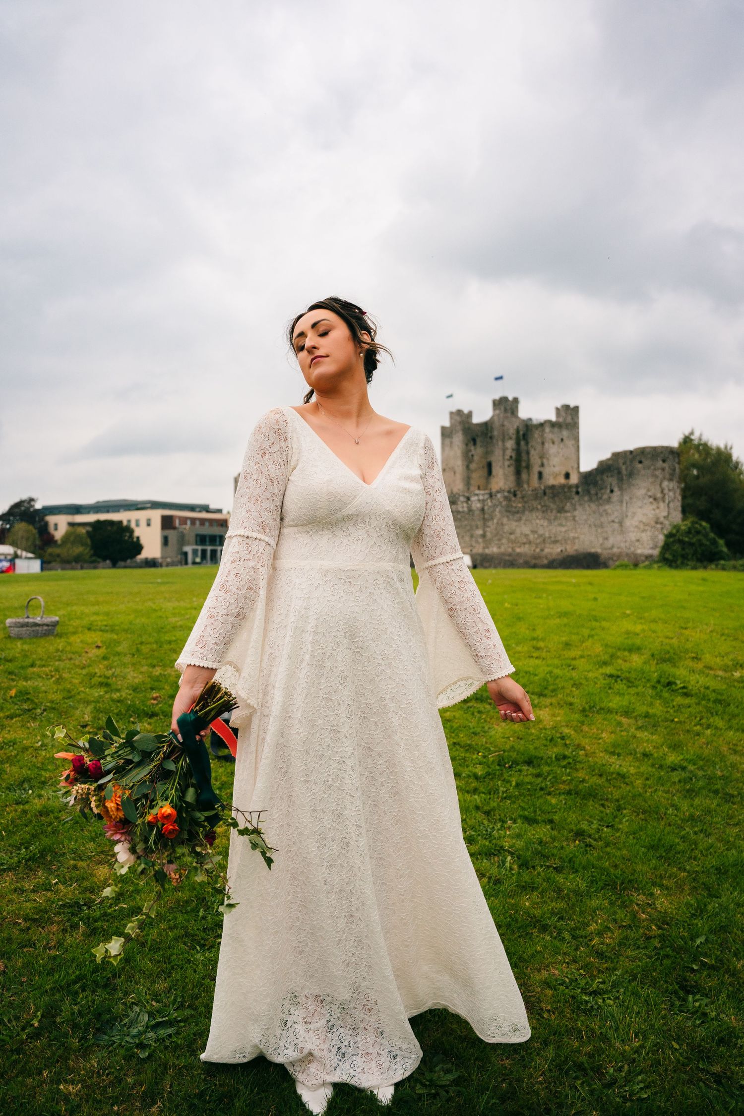 Ethereal bridal portraits featuring a flowing lace dress against a castle backdrop on green hills.Wedding Photography Trim Castle Ireland