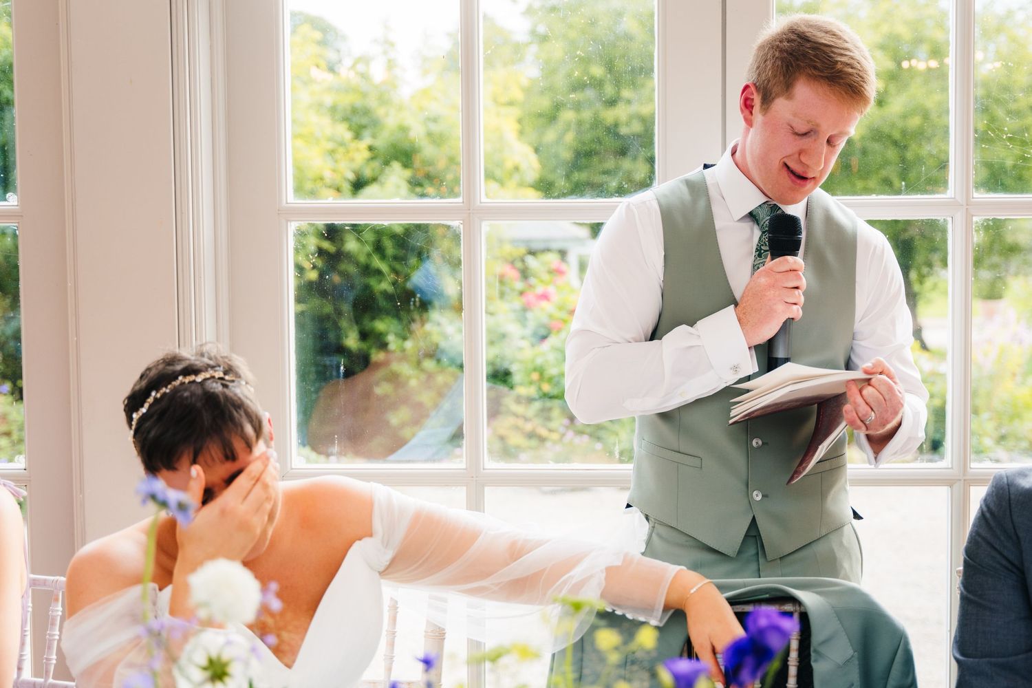 Millhouse slane wedding photographer dublin Wedding reception guests react emotionally during speeches in a sunlit room.
