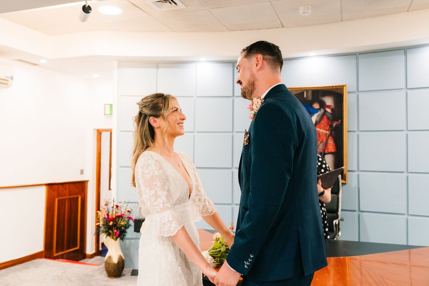 house dublin registry office Dublin CiBride and groom share a joyful first look moment, holding hands and smiling in a bright wedding venue.