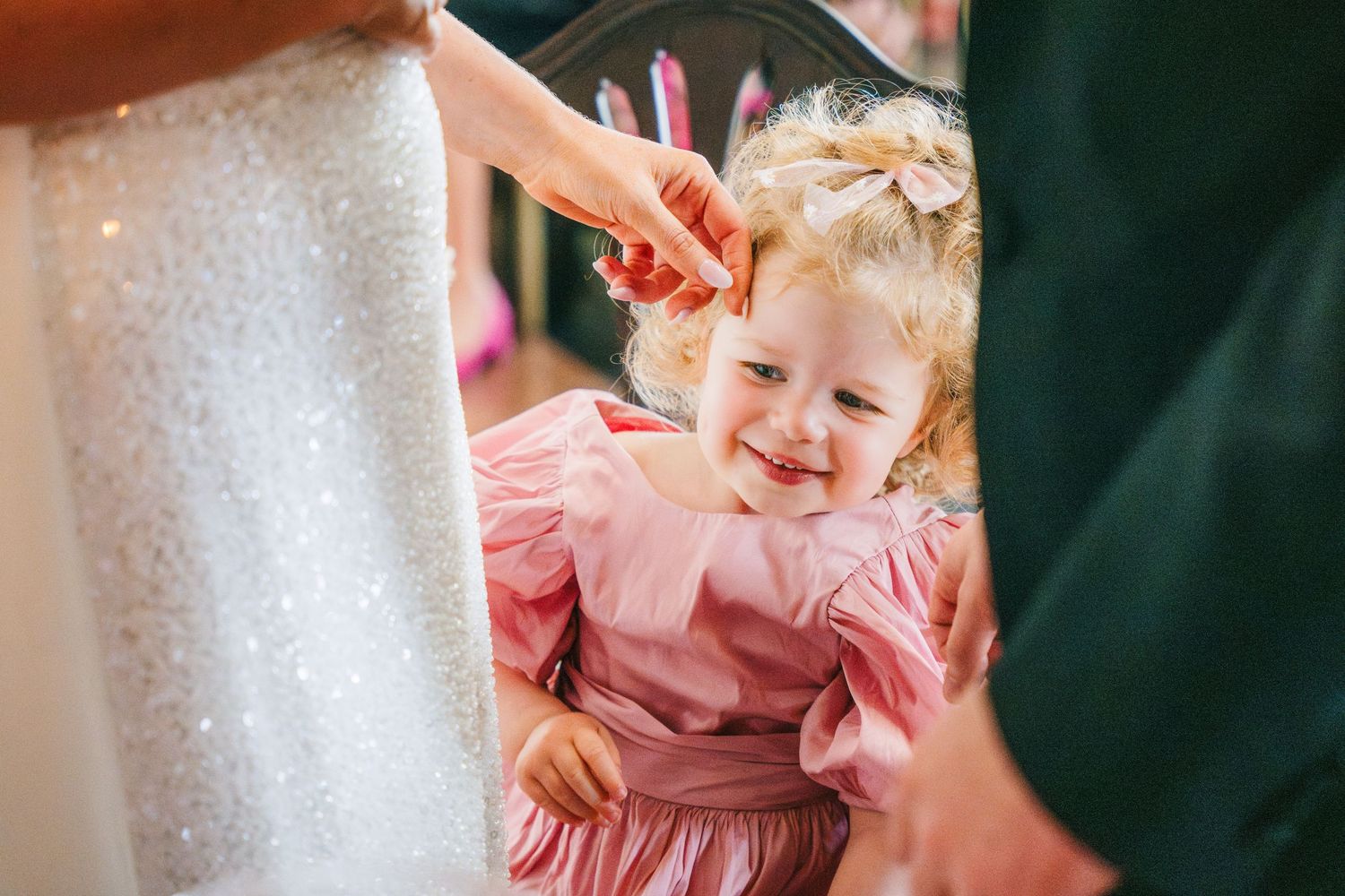 A couple shares a joyful moment with a small child in a pink dress during a wedding celebration.  city hall dublin wedding photos