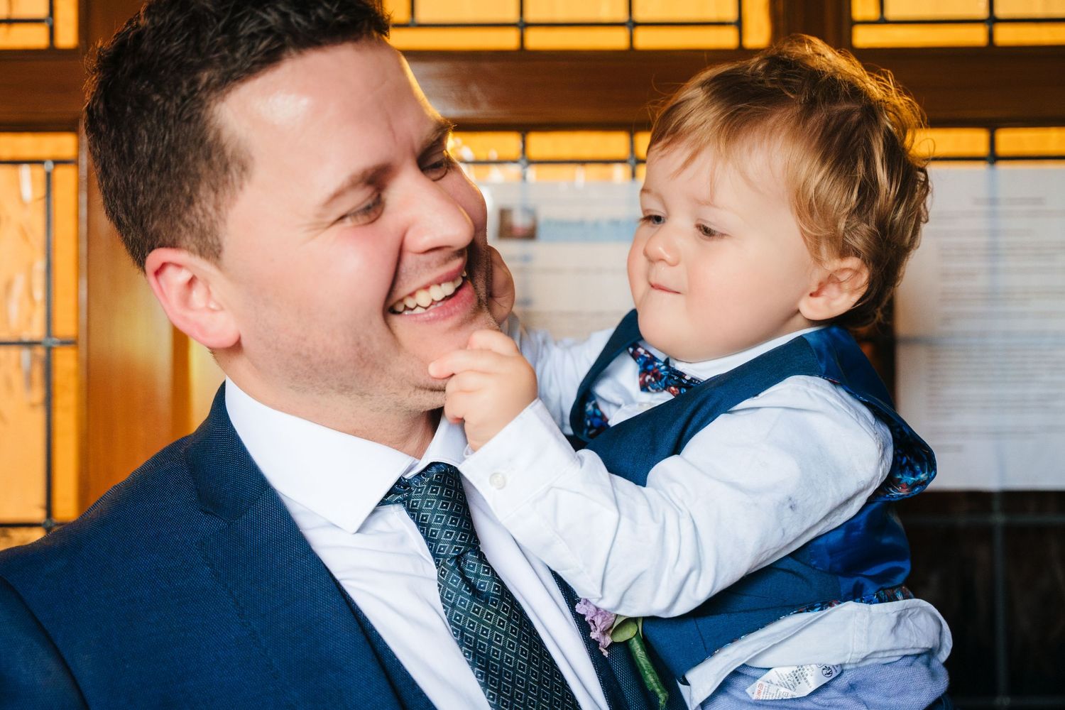 A joyful moment shared between loved ones during a wedding celebration in formal attire.
