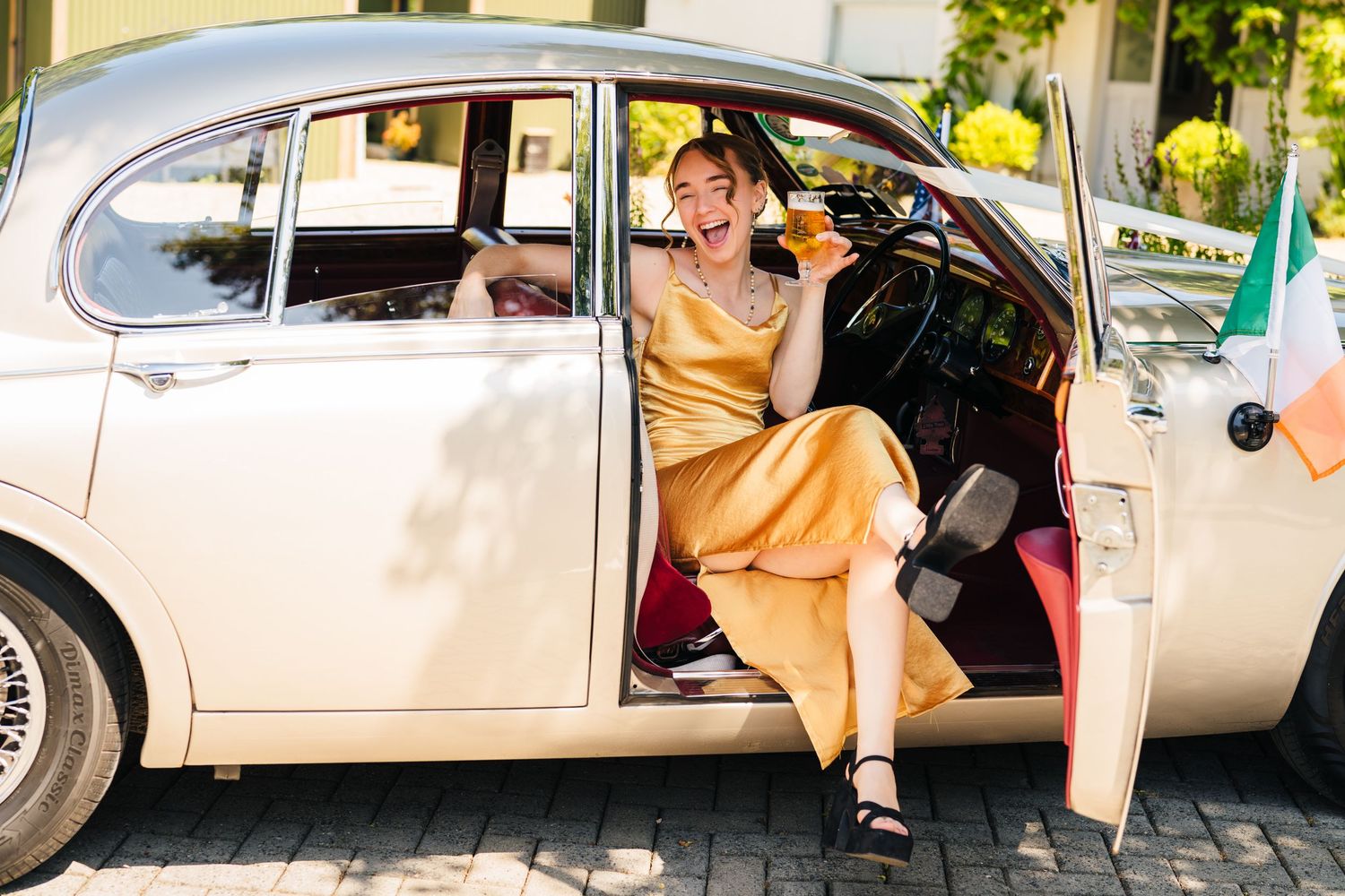 Poulaphouca Wedding photographer wicklow  Woman in yellow dress sitting elegantly in vintage cream-colored Volkswagen Beetle with door open.