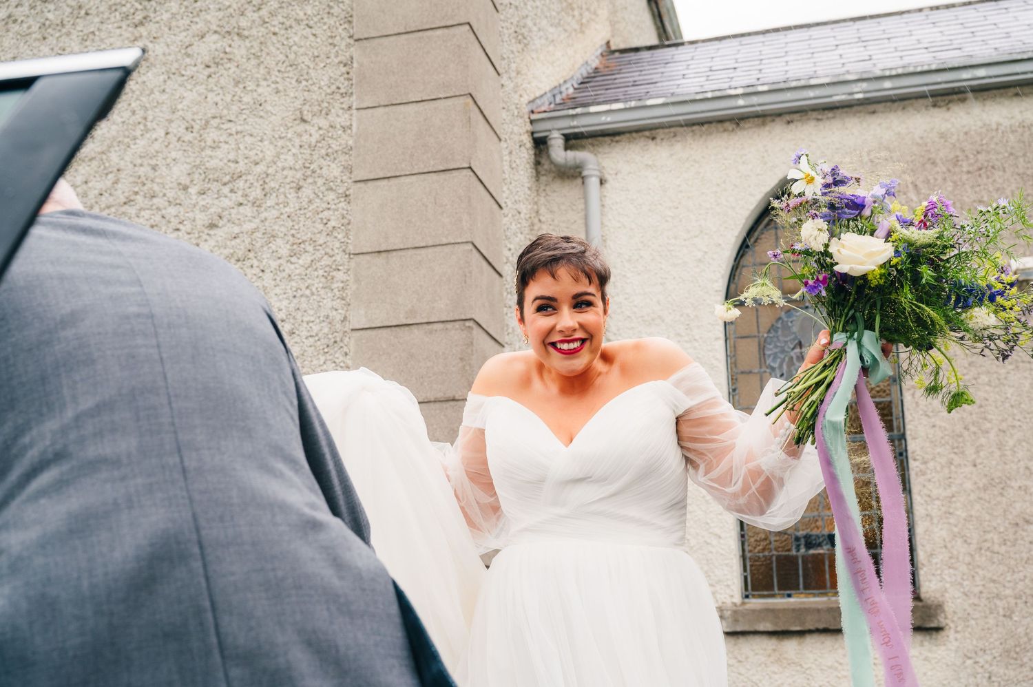 Millhouse slane wedding photographer dublin A joyful moment captured during a wedding ceremony outside a stone building.