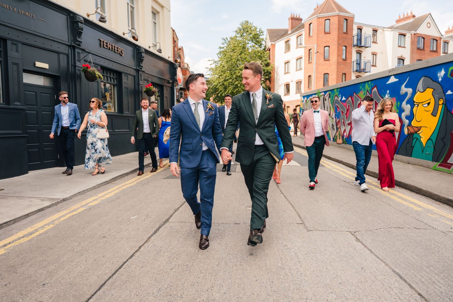 Groups walking down a city street during a wedding celebration. Same sex wedding PHOTOGRAPHER Dublin