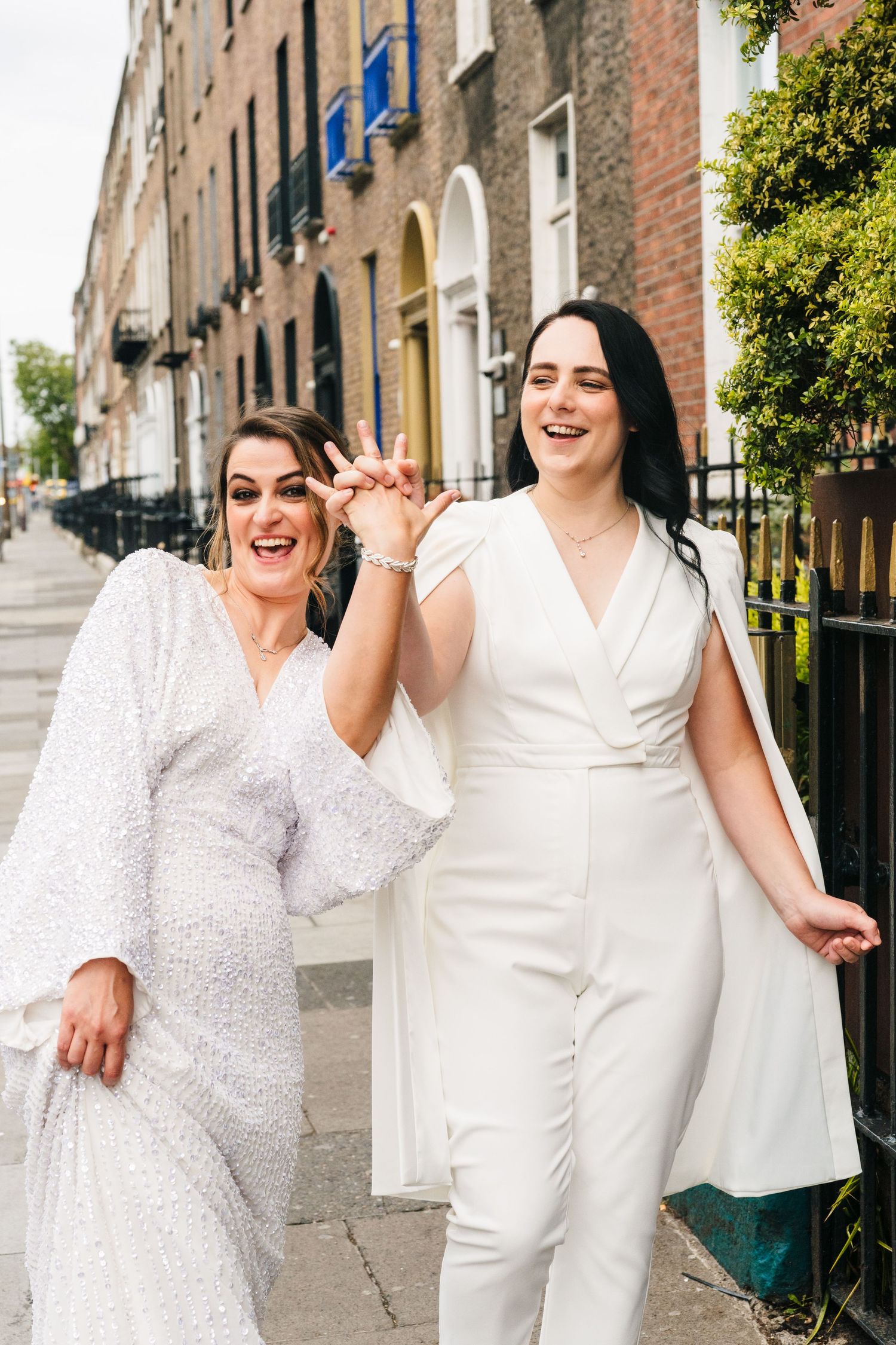 Two people in white outfits share a joyful moment together on a historic Dublin street with Georgian architecture. House Dublin Wedding Phot