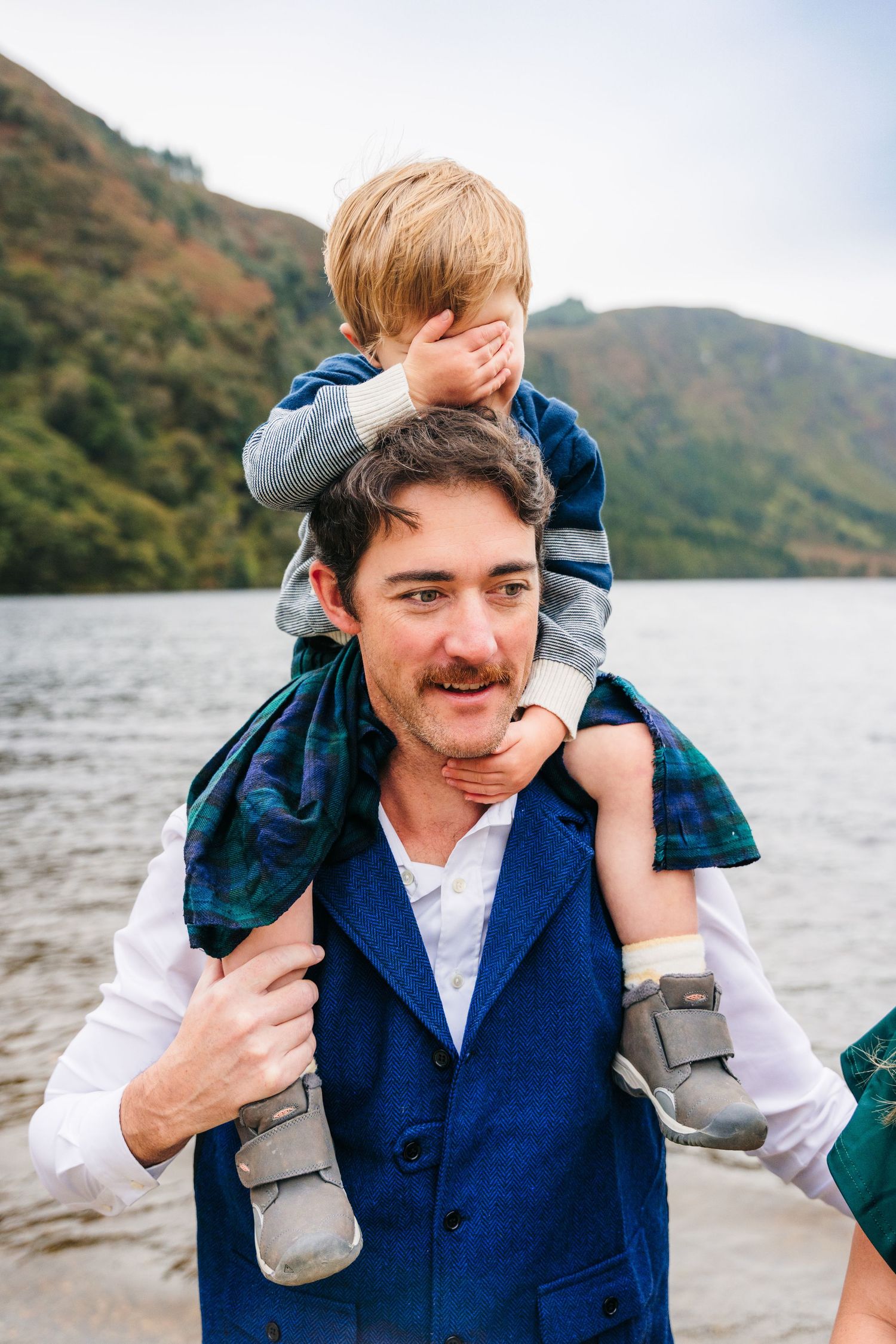 A playful moment outdoors by a lake with mountains in the background.Family photogrAPHER DUBLIN