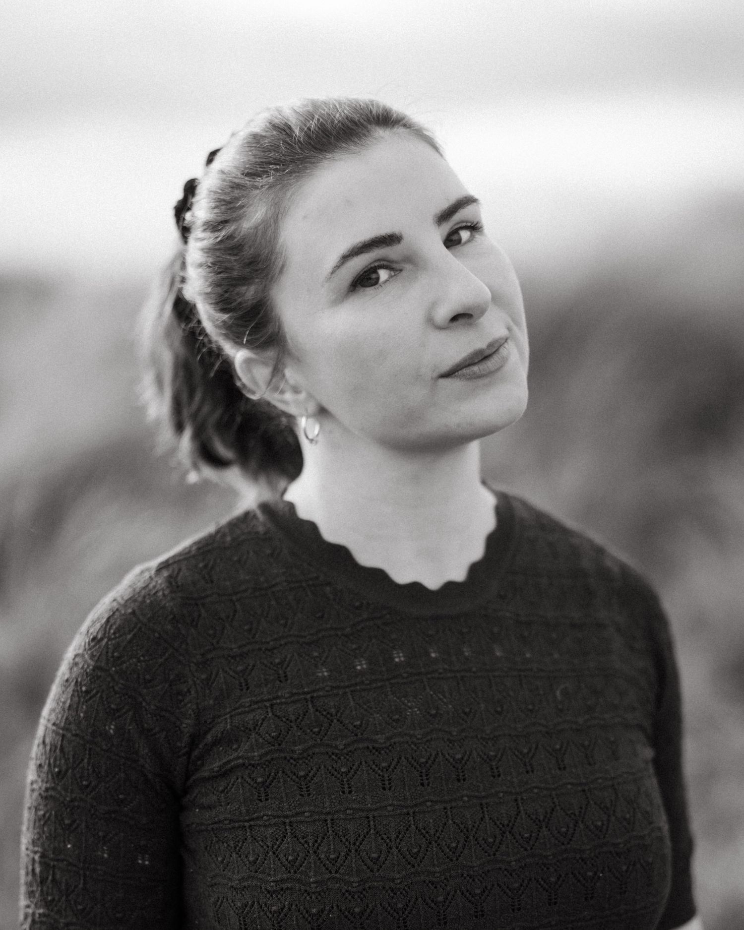 A person in a black sweater looks up at the sky, shown in five sequential poses against a blurred background. PHOTOGRAPHER Dublin