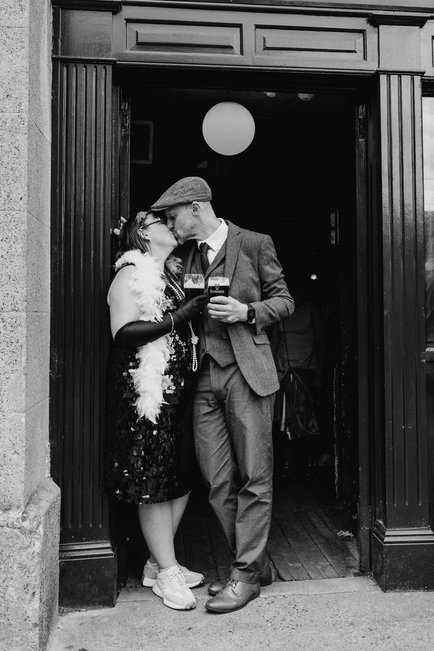Black and white image showing someone lighting a cigarette on the street while standing near a doorway. PHOTOGRAPHER Dublin ireland