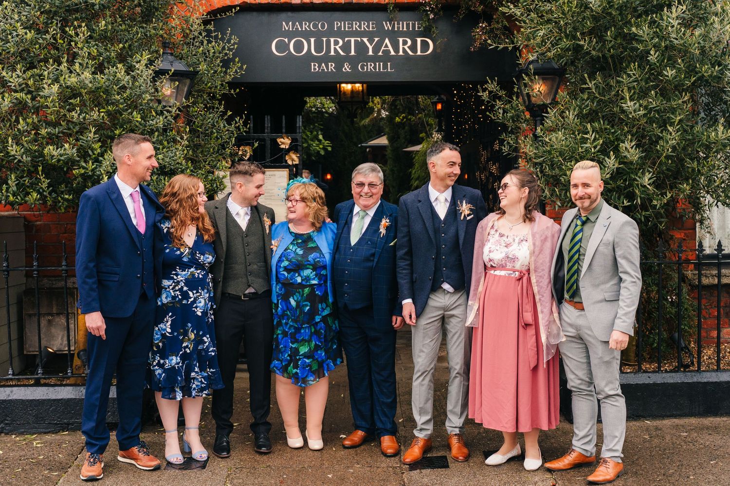 Group photo of wedding party members outside the Courtyard venue entrance. Marco Pierre Dublin Wedding Photographer