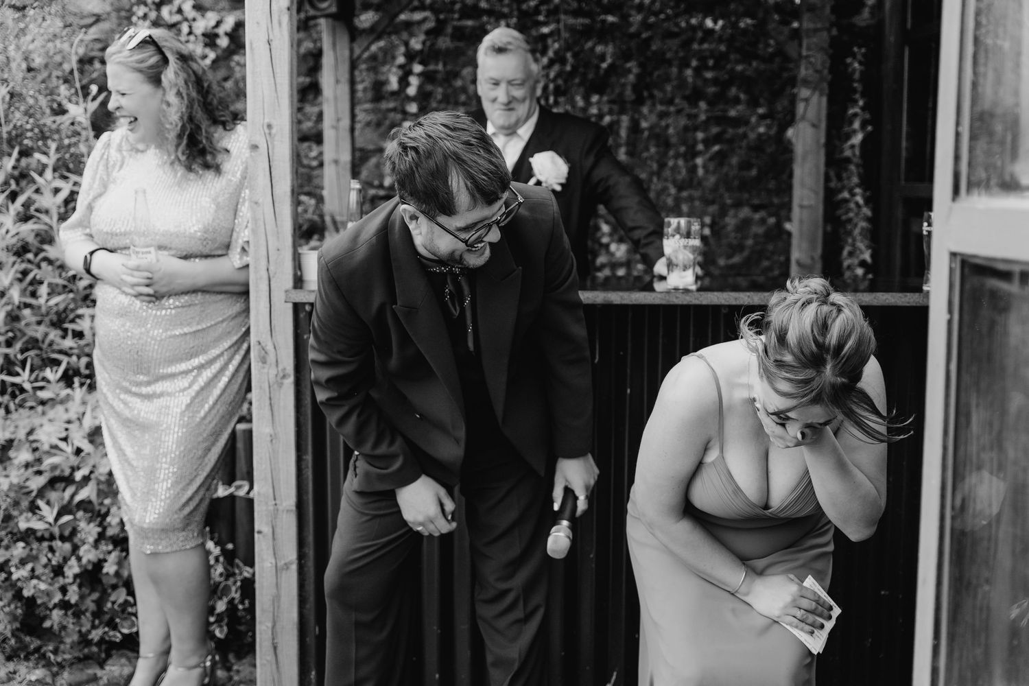 Wedding photographer dublin A candid black and white moment showing wedding party members sharing laughter.