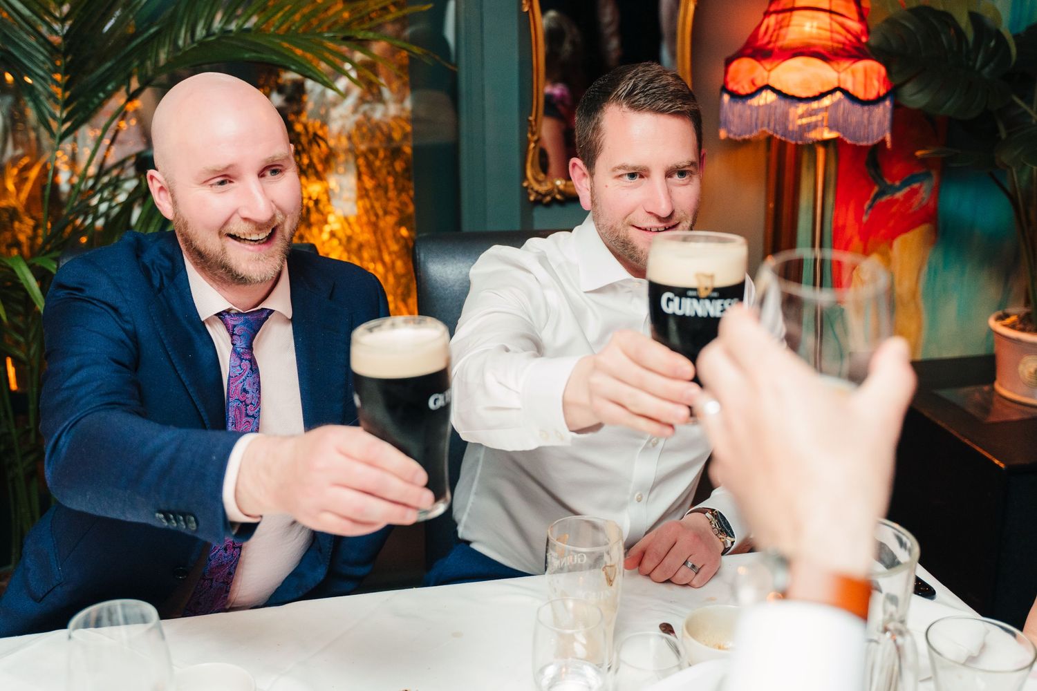 Wedding guests toasting and drinking Guinness beer at a celebratory gathering. Marco Pierre Dublin Wedding Photographer