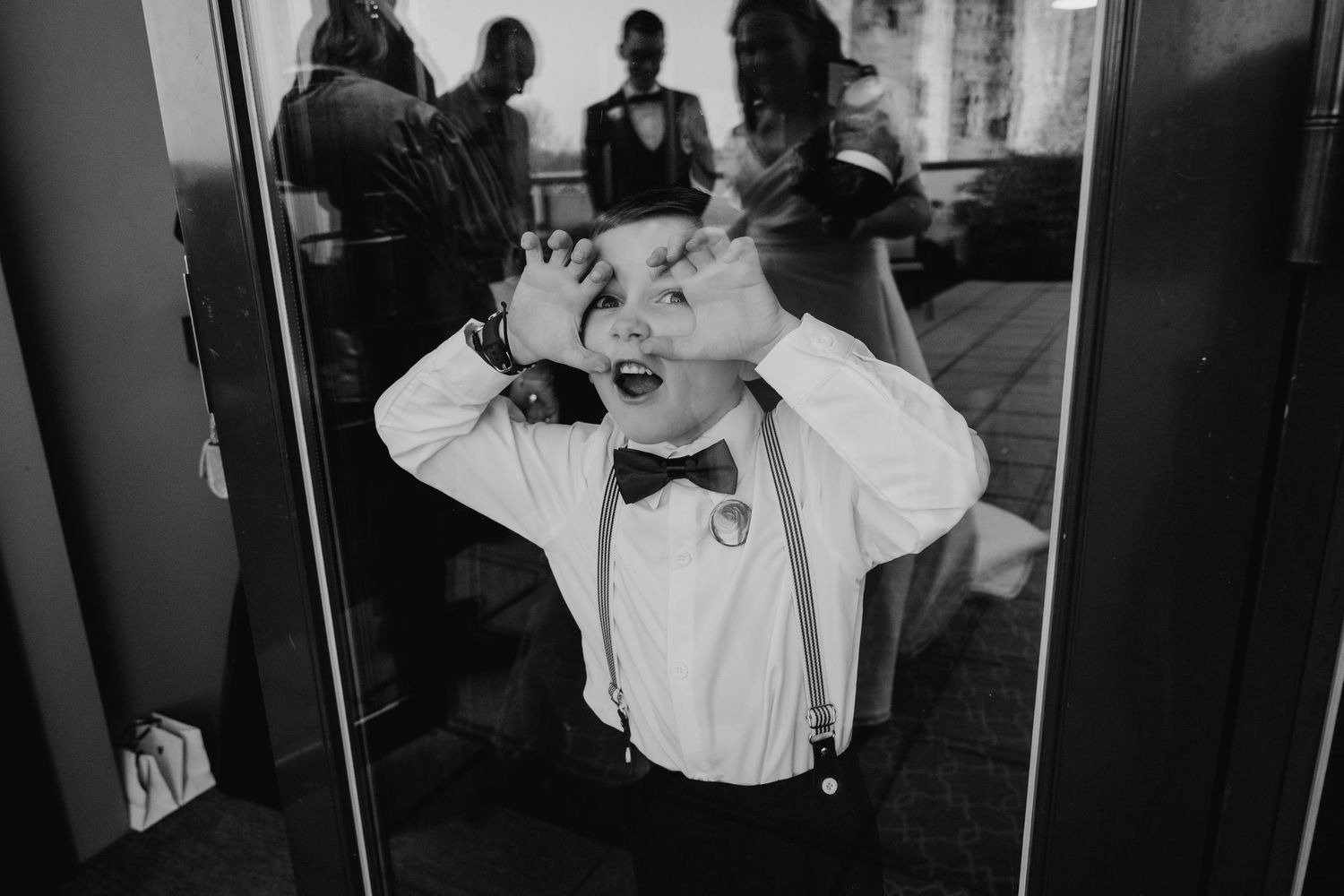 Black and white photo of playful moment during formal event with bow tie.  Wedding PHOTOGRAPHER Trim Castle