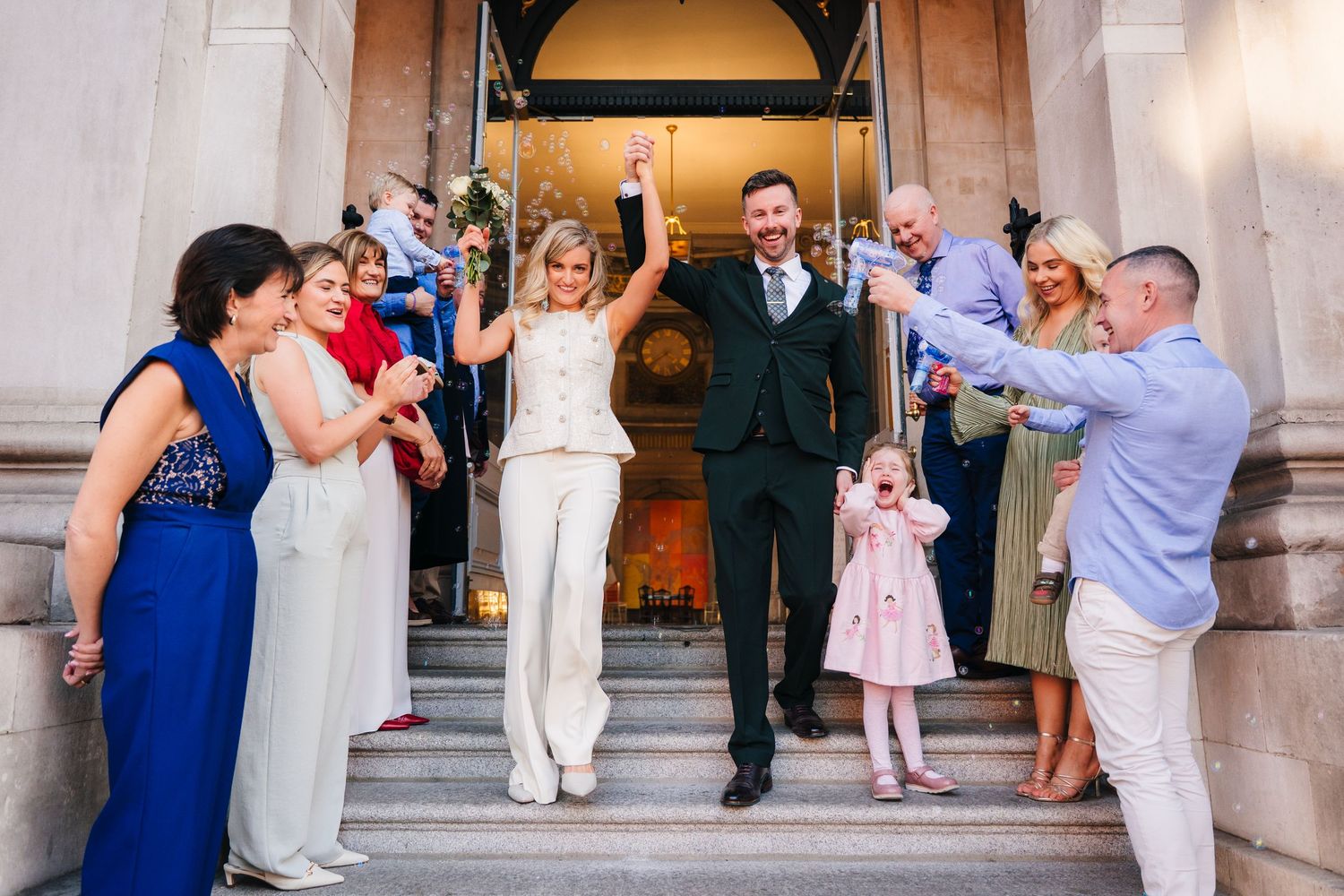 Wedding celebration with guests gathered on church steps. City Hall Dublin wedding photogrAPher