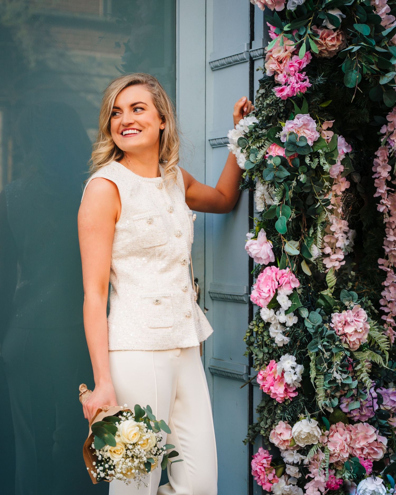 A bridal portrait series with pink and purple floral decor against a blue-grey wall. City Hall Dublin wedding photogrAPher