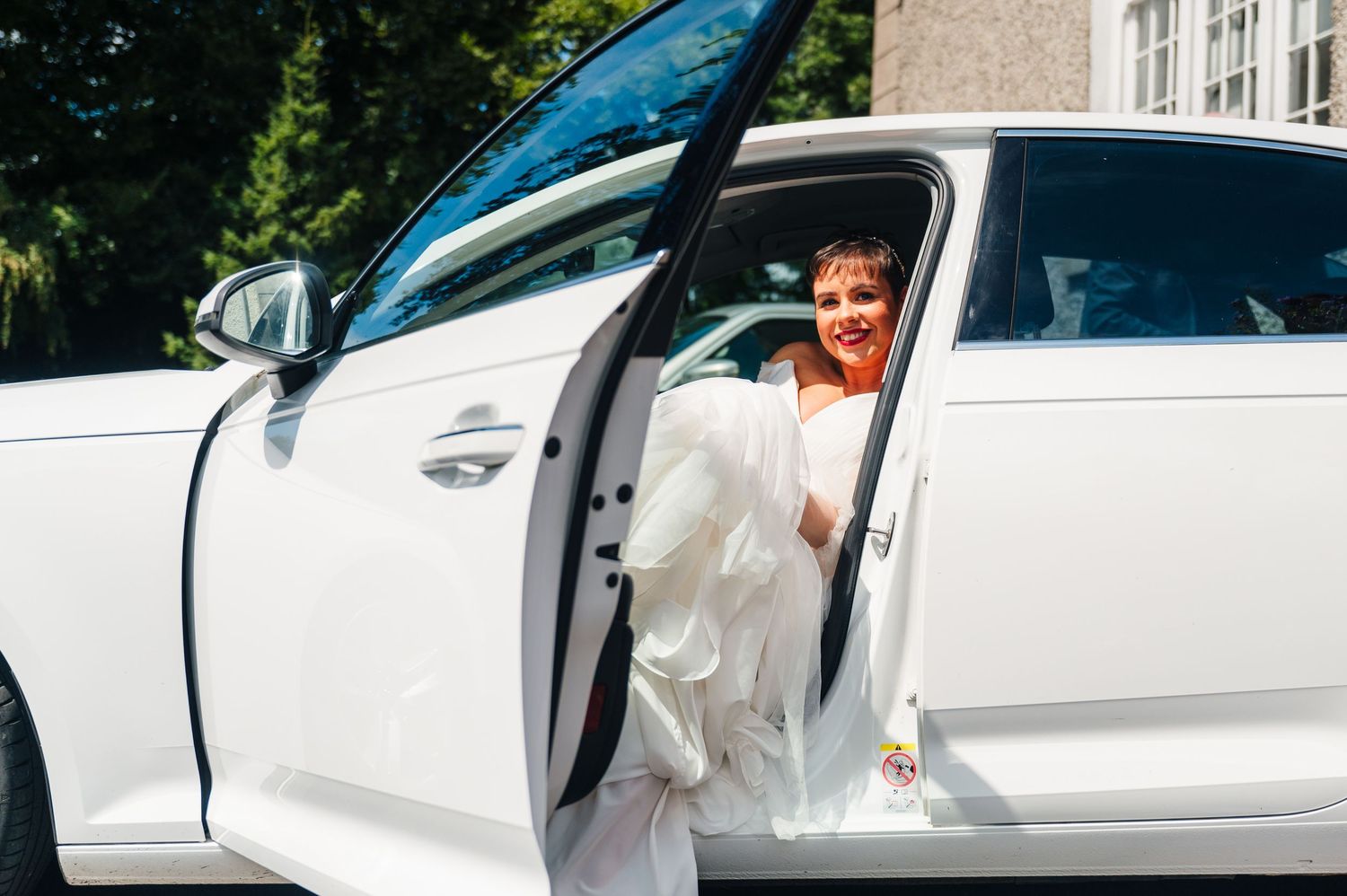 Millhouse slane wedding photographer dublin White wedding car parked outside with people getting ready to enter.