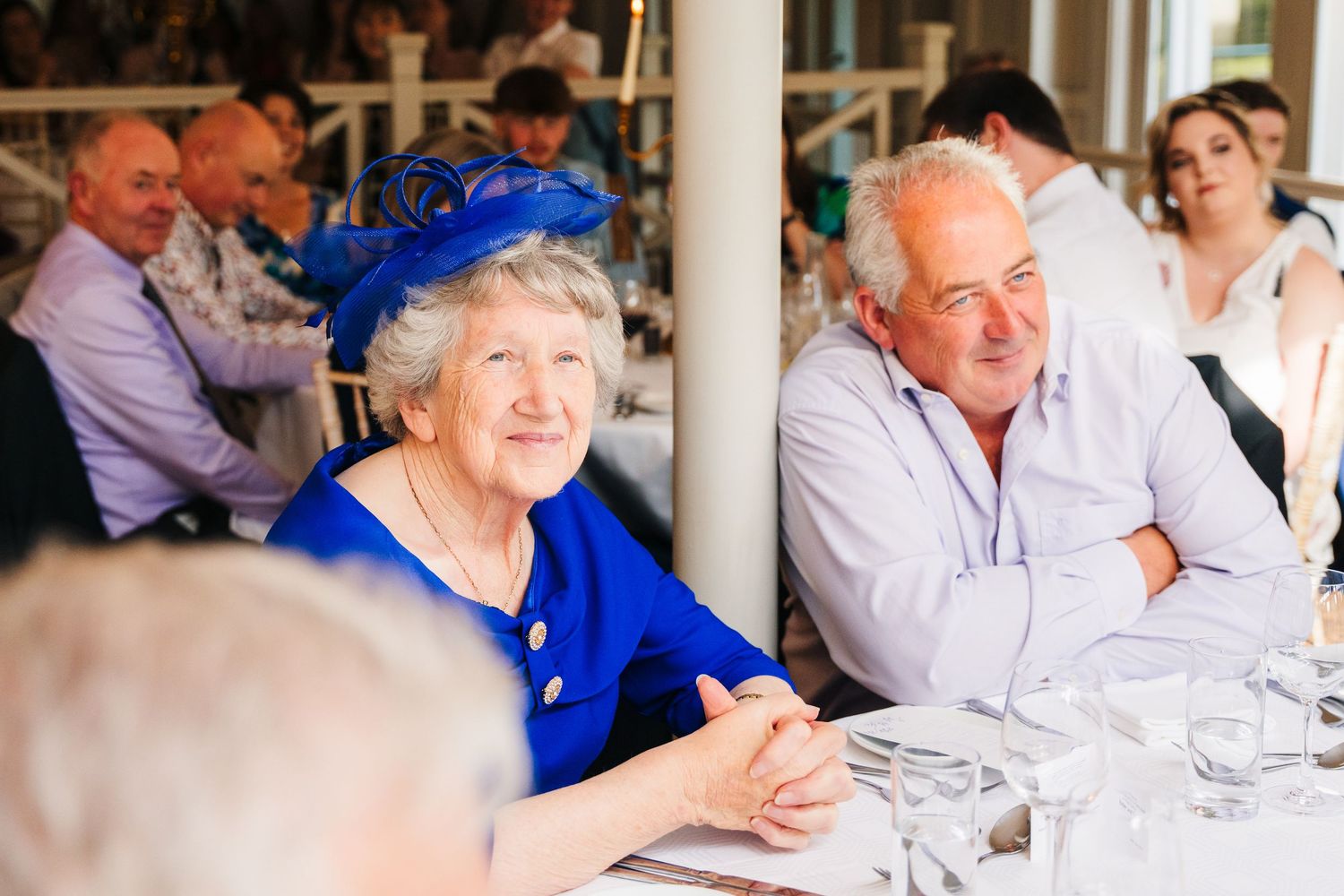 Millhouse slane wedding photographer dublin Wedding reception guests enjoying conversation at elegant table setting with white linens.