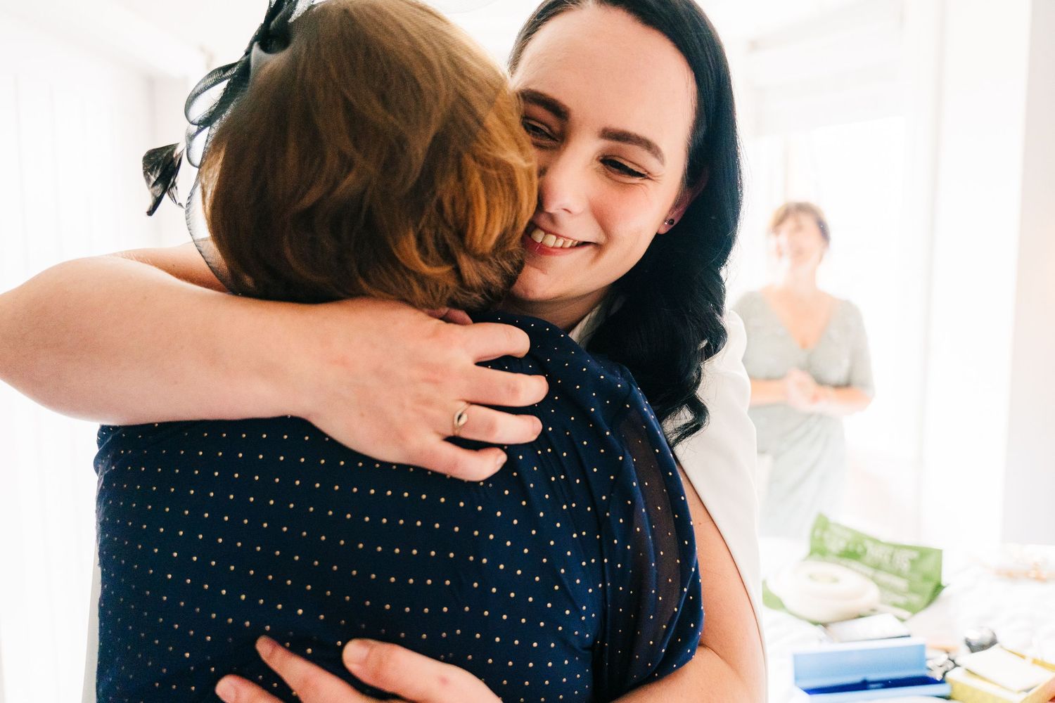 People sharing warm embraces at a social gathering with joyful expressions of happiness and emotion. House Dublin Wedding Photographer