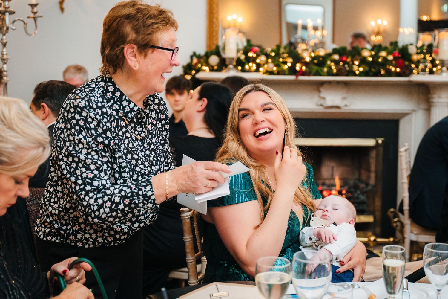 Wedding reception guests laugh and celebrate at decorated indoor venue with holiday decor. Stephens green club dublin Wedding photographer