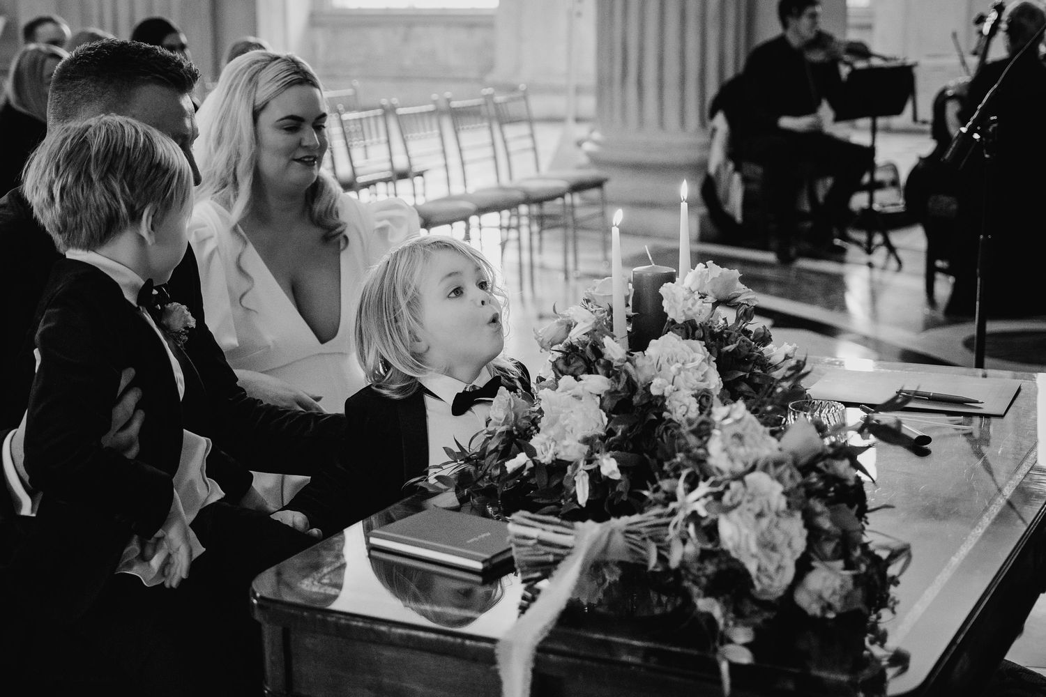 Black and white photo showing guests seated at elegant wedding reception tables with floral centerpieces. Wedding Photographer Dublin Irelan