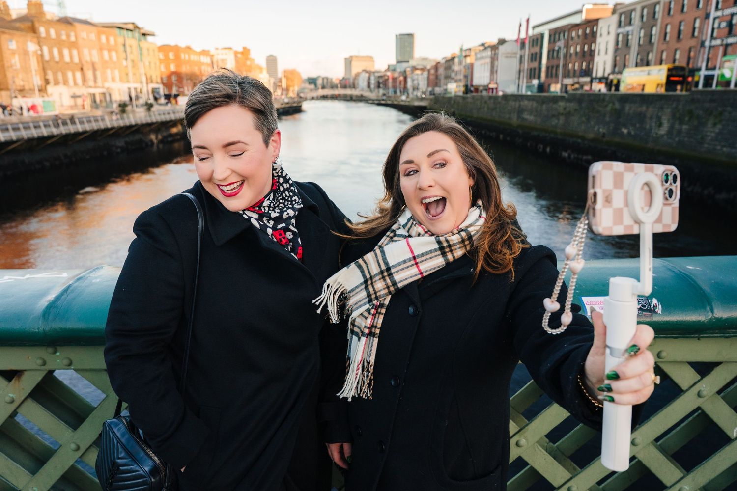 Couple enjoying a romantic stroll by the water in Dublin's city center during golden hour.