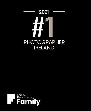 An award badge designating '#1 Photographer Ireland 2021' in white text on black background with 'This is Reportage Family' logo. wedding ph