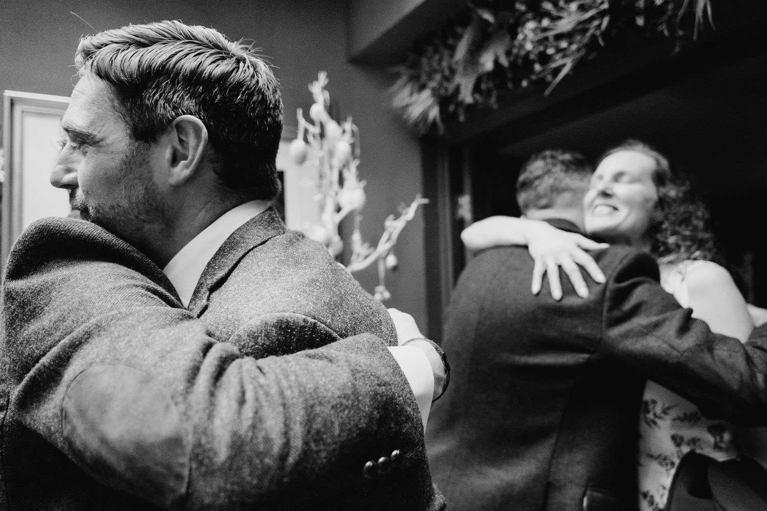 Black and white photo showing people embracing at a formal event. Marco Pierre Dublin Wedding Photographer
