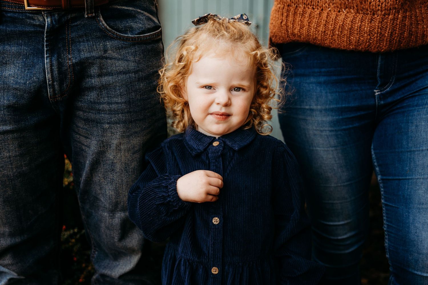 Two people wearing blue jeans and sweaters pose together in a warm autumn portrait session. family PHOTOGRAPHER Dublin