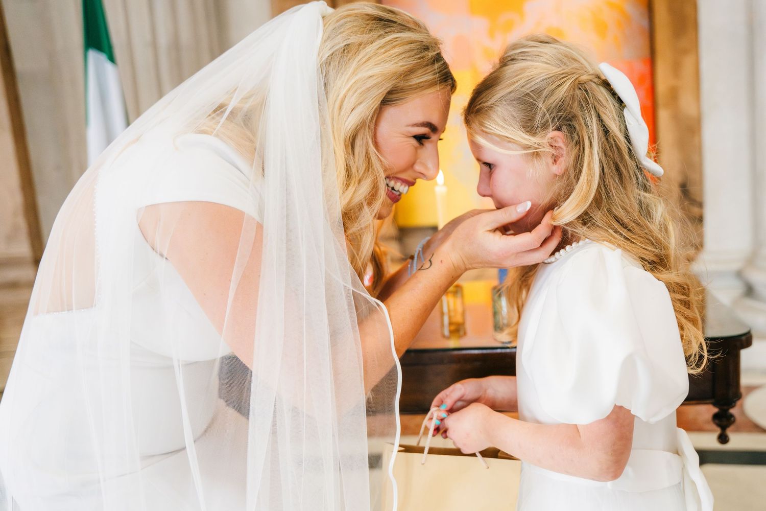 Wedding ceremony taking place in an elegant church interior with white columns and veil details. Wedding Photographer Dublin Ireland